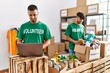 © Krakenimages.com - Young hispanic volunteers using laptop working at charity center.