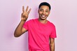 © Krakenimages.com - Young african american man wearing casua t shirt showing and pointing up with fingers number three while smiling confident and happy.