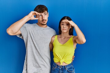 Sticker - Young hispanic couple standing together over blue background worried and stressed about a problem with hand on forehead, nervous and anxious for crisis