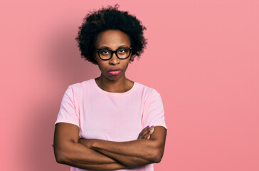 Poster - African american woman with afro hair wearing casual clothes and glasses skeptic and nervous, disapproving expression on face with crossed arms. negative person.