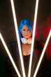 © golubovy - Cyber girl. Futuristic style. Generation Z. Cyberpunk brave confident woman with headphones in LED light lamp red neon dark studio smoke dramatic background.