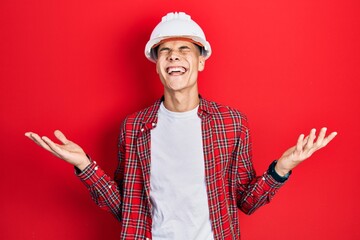 Poster - Young hispanic man wearing architect hardhat celebrating mad and crazy for success with arms raised and closed eyes screaming excited. winner concept