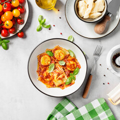 Homemade italian ravioli pasta, stuffed with spinach and ricotta ,served with tomato sauce, parmesan cheese and fresh basil leaves . Top view	