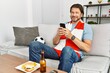 © Krakenimages.com - Middle age caucasian man using smartphone watching soccer match at home