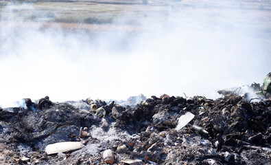 Trash and smoke representing a zone disaster and bad waste management. Planet problems concept. Nasty rubbish industry and dirty ecology on our planet. Destruction with lots of polluted materials