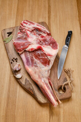 Wall Mural - Raw lamb meat. Fresh cut of Lamb leg fillet with spices on wooden kitchen board. Raw steak on cutting board ready to cook. Selective focus