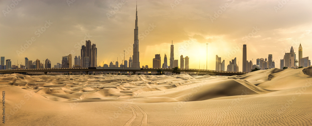 Dubai downtown skyline panorama at sunset with desert sand, United Arab Emirates