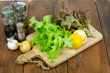 Wall Mural - lettuce leaves on wooden cutting board, set of spices for cooking. Studio Photo.