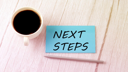 NEXT STEPS text on the blue sticker with cofee and pen