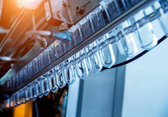 Poster - Automatic filling machine pours water into plastic PET bottles at modern beverage plant.