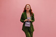 © Look! - Portrait of relaxed, inspiring caucasian young girl with closed eyes and red wavy hair indoors. Lady in business green suit and lilac bag. Emotional reaction to happiness, concept