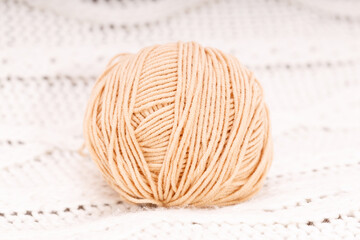 Aufkleber - brown wool coil on a knitted white tablecloth