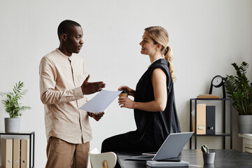 Wall Mural - Minimal side view portrait of two business people discussing project by desk in office, copy space