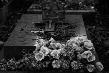 Autumn At Cemetery. Faded Leaves On Grave And Colorful Artificial Flowers. Eternal Memory, Mourning, Grief Concepts.  Black White Historic Photo