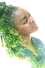 Wall Mural - A portrait of a pretty woman dissolving into an image of foliage. Double exposure.