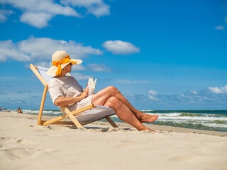 Woman relaxing on beach sitting on sunbed
