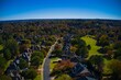 Panoramic aerial view of luxury homes in an upscale neighborhood in the suburbs with beautiful  colors of leaves on the trees in the subdivision during fall of 2021.