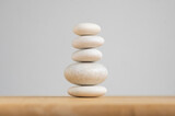 Fototapeta Desenie - Stone cairn on white background, five stones tower, simple poise stones, simplicity harmony and balance, rock zen