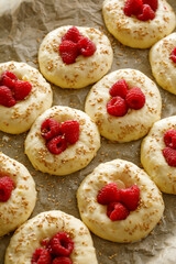 Wall Mural - Raw raspberry sweet  buns  prepared for baking on baking paper,  close up view. Traditional yeast buns