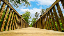 Wooden Footbridge Through Nature From Ground Perspective
