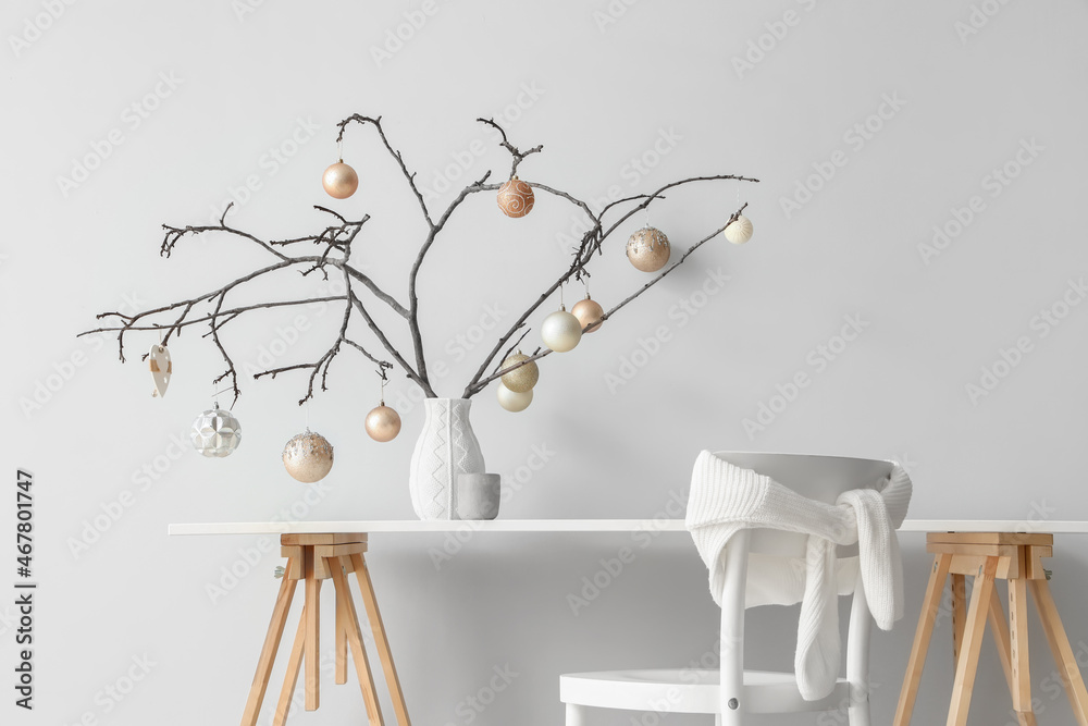 White table and chair with Christmas decoration on light wall background