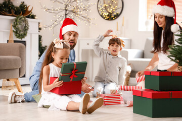 Cute little girl opening Christmas gift box at home