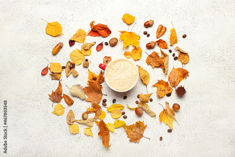 Autumn composition with cup of coffee on light background