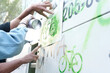 Hands painting green bike graffiti with stencil during the Global Climate Strike