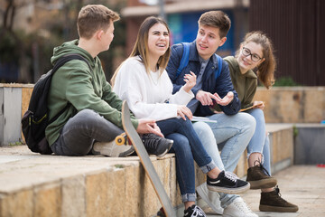 Four teenagers are talking about play on walk on the street