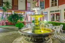 Entrance Of A Hotel With Fountain At Night.