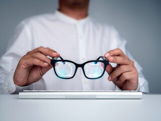 Smart glasses. Businessman in white shirt holding smart glasses with digital information on virtual screen high tech interface. Futuristic technology and augmented reality concept.