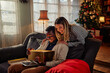 © bernardbodo - Christmas couple enjoying sharing presents at home.