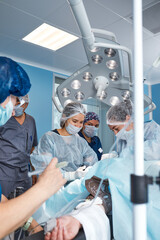 Wall Mural - Concentrated Surgical team operating a patient in an operation theater. Well-trained anesthesiologist with years of training with complex machines follows the patient throughout the surgery