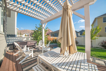 Empty patio exterior of a house and a table that has a closed umbrella.