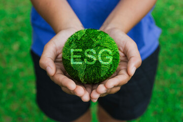 Hands holding the earth ball that writes the word ESG, ESG concept of environmental, social and governance.