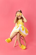 © Lisa Tichané - Silly little girl on pink background holding lemons against her eyes