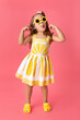 © Lisa Tichané - Little girl on pink background wearing lemon dress making funny face