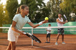 © New Africa - Happy family playing tennis on court outdoors