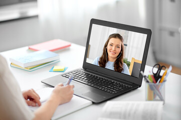 Wall Mural - education, school and distant learning concept - female student woman with laptop computer having video call or online class with teacher at home