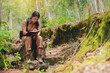 © Panumas - Biologist or botanist recording information about small tropical plants in forest. The concept of hiking to study and research botanical gardens by searching for information.