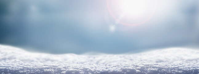 a cold winter snow landscape with cold blue background with sun flare for a traditional christmas sc