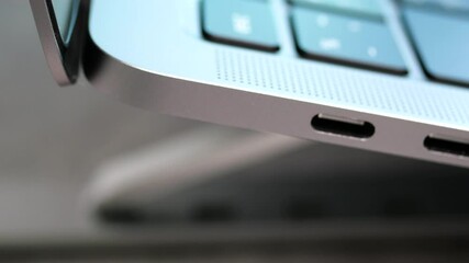 Wall Mural - Close up rotation movement of USB type c port for connection in laptop with blur Thai keyboard