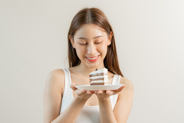 Portrait of attractive beautiful girl, asian young teenage woman holding a piece of chocolate cake, emotion enjoy sweet. Dieting, diet for loss weight to slim. Isolated white background, copy space.