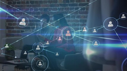 Poster - Animation of network of people icons over male and female colleague using laptop on couch in office