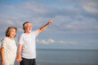 © sutthichai - An Asian couple walking together on the beach. Retirement and holiday concept.