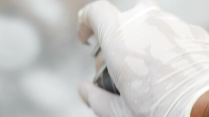 Poster - A hand with a white glove coloring glass in white with a spray paint