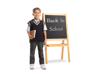 Sticker - Schoolboy in a uniform holding a book and standing in front of a chalk board with text back to school