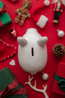 © ink drop - Festive Christmas financial savings concept. White piggy bank money box with presents and decorations