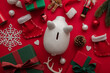 © ink drop - Festive Christmas financial savings concept. White piggy bank money box with presents and decorations