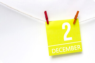 December 2nd. Day 2 of month, Calendar date. Paper cards with calendar day hanging rope with clothespins on white background. Winter month, day of the year concept.